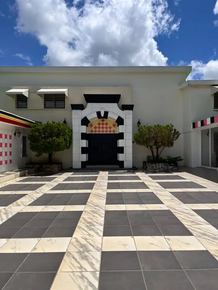 Le Portail — Une arche rayée sur la cour en damier.
