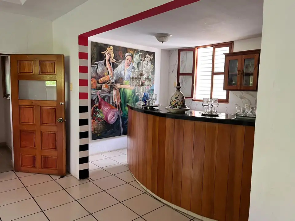 Bar de Réception — Le bar de réception, en bois chaleureux sous une fresque.