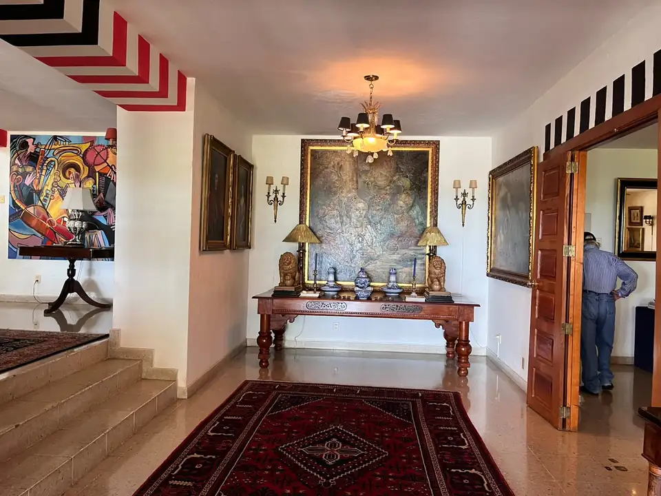 Le Vestibule — Tapis persan, lustre de bronze et un maître ancien doré.